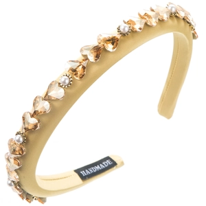 Macro shot of amber crystal hearts and white pearls on yellow baroque sponge headband