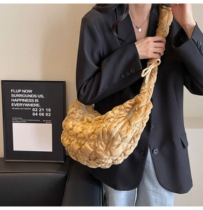 Detail of ginger pleated cloud bag showing velvet quilted texture and soft bow strap
