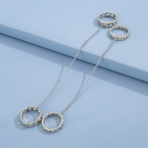 Punk style silver chain rings set displayed on a light blue geometric platform