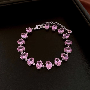 Macro detail of pink zircon gradient bracelet with silver finish on black leather texture