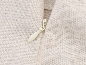 Dettaglio macro della cerniera invisibile sul set in tessuto di lino beige