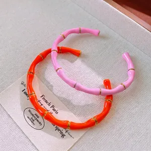 Bracciali in smalto stile bambù arancio e rosa con accenti dorati e design aperto
