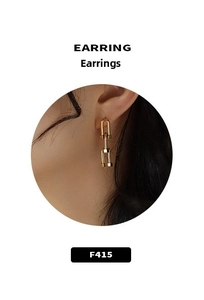 Detail of gold-plated U-shaped link earrings with a polished industrial metal finish