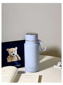 Light blue insulated water bottle with matte finish and portable silicone carry strap