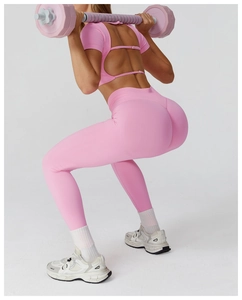 Pink high-waist yoga pants and open-back top set showing flexible squat fit on model