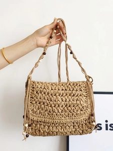 Handmade woven straw crossbody bag with fan-shaped flap and decorative wooden beads