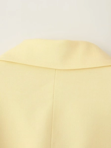 Détail d'un blazer jaune clair montrant la texture sergé et les coutures du dos