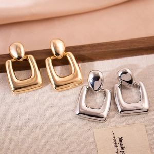Polished gold and silver geometric hollow rectangular drop earrings on a silk background
