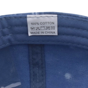 Detailed view of 100% cotton wash label inside a blue denim washed baseball cap