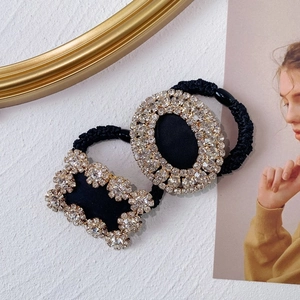 Detailed close-up of luxury black elastic hair rings with sparkling crystal embellishments