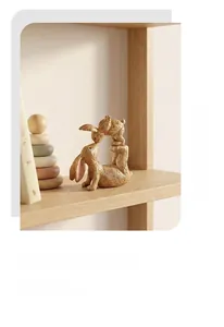 Detail of minimalist resin mother and child rabbit sculpture on light wooden bookshelf