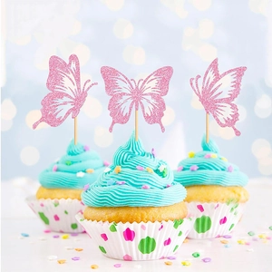 Close-up of three pink glitter butterfly cake toppers on cupcakes with blue frosting