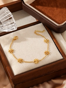 Detail of adjustable gold stainless steel daisy chain bracelet on a linen display tray