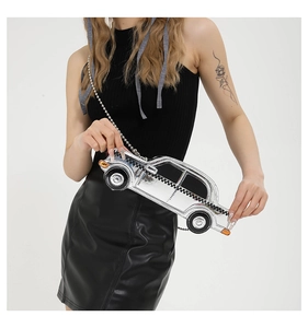 Detail of silver metallic car-shaped crossbody bag with checkerboard pattern and chain