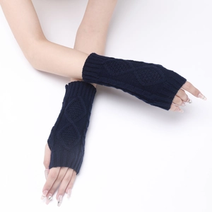 Close-up of navy blue knit fingerless gloves featuring a detailed diamond cable pattern