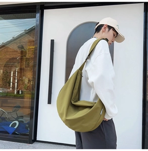 Detail view of the olive green crescent bag showing large capacity and smooth oxford fabric