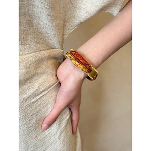 Vintage gold cuff with red and yellow silk wrap pattern, elegant bracelet for women