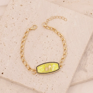 Detail of gold Leo zodiac bracelet with yellow enamel oval tag and black zircon pavé stones