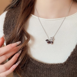 Gros plan du collier carlin en émail avec pendentif fleur de perle sur le cou du mannequin