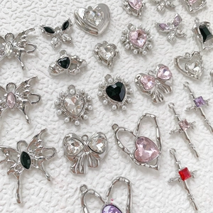 Close-up of assorted silver charms with colorful gemstones and pearls for DIY jewelry