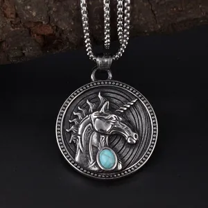 Vintage unicorn pendant necklace in silver with turquoise gemstone on wooden background