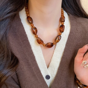 Model wearing vintage brown amber acrylic beaded necklace and matching bracelet set