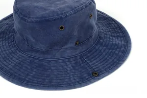 Detail view of navy denim bucket hat featuring vintage brass eyelets and washed texture