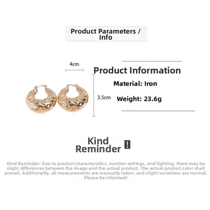 Macro detail of chunky gold-plated hammered hoop earrings with size and weight metrics