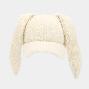 Macro shot of fluffy white faux fur texture and long rabbit ears on a baseball cap