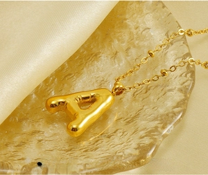 Detail of 18K gold plated stainless steel 3D bubble letter A pendant on delicate chain