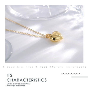 Detailed view of polished 3D gold heart pendant on a delicate chain with shadows