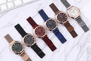 Detailed view of women's quartz watches with Roman numeral dials and magnetic mesh straps