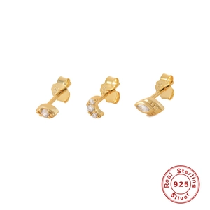 Detailed macro of gold 925 silver earring set with eye, moon and leaf studs and crystals
