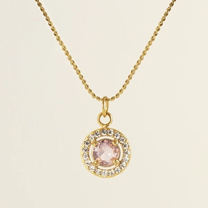 Macro view of 18K gold circular necklace featuring pink gemstone and cubic zirconia