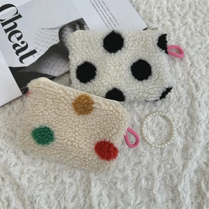 Detailed view of plush polka dot makeup pouches with soft texture and pink zipper pulls