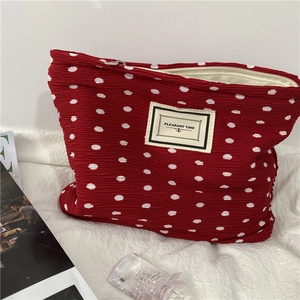 Close-up of red polka dot chiffon makeup bag with Pleasant Time label and zipper detail