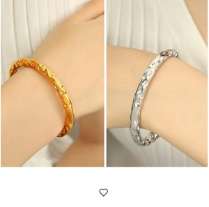 Detailed view of hammered texture on gold and silver stainless steel open bangles