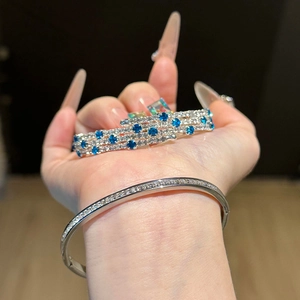 Macro shot of silver-tone layered bracelet with sparkling zircon and blue gemstones