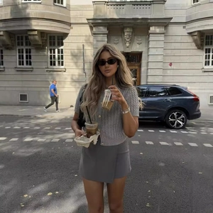Chic grey knit two-piece set featuring short-sleeve cardigan and mini skirt for women