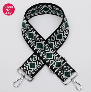 Detalle de correa tejida ajustable para bolso con mosquetones y hebillas plateadas