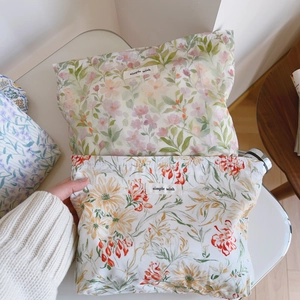 Vue détaillée d'une trousse à maquillage en coton avec motifs floraux et étiquette