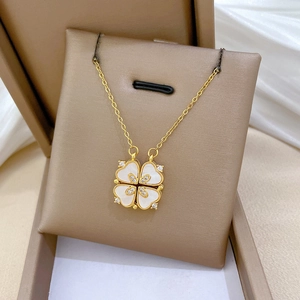 Détail du pendentif trèfle doré avec nacre blanche et cristaux scintillants