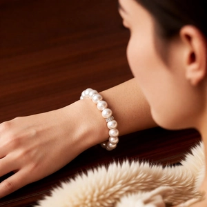 Close-up of elegant pearl bracelet with zircon flower charm on model's wrist