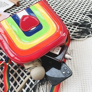 Internal view of rainbow patchwork crossbody bag showing smartphone and perfume storage