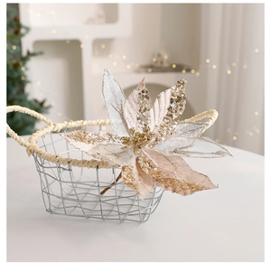 Gros plan de fleurs de Noël pailletées champagne dans un panier en métal blanc