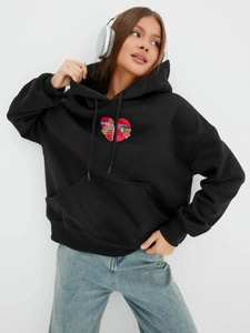 Λεπτομέρεια μαύρου hoodie με στάμπα Breaking Hearts και απαλή υφή πλεκτού υφάσματος