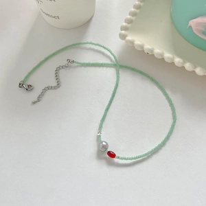 Détail d'un collier de perles grises et agate rouge avec fermoir mousqueton