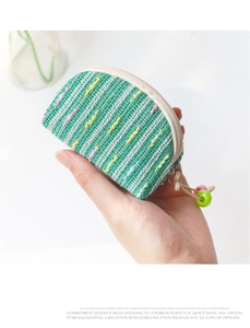 Close-up of a green hand-woven mini coin purse with colorful beads and zipper detail