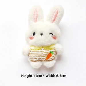 Detail of 11cm plush bunny charm with soft fur and embroidered carrot on striped outfit