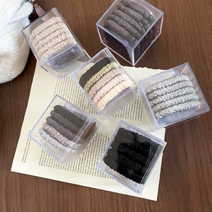 Close-up of a 5-piece set of elastic fabric hair ties in a clear acrylic square gift box